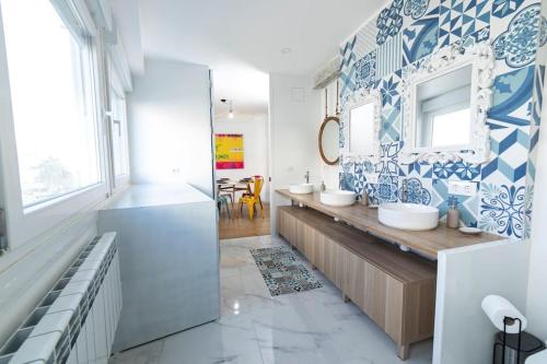 a bathroom with two sinks and a mirror at Amplio piso de diseño . in Vigo