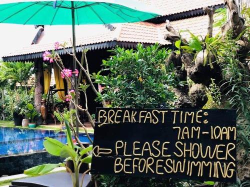 a sign in front of a house with an umbrella at Moloppor Villa in Battambang