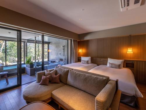 una camera d'albergo con due letti e un divano di Fufu Hakone a Hakone