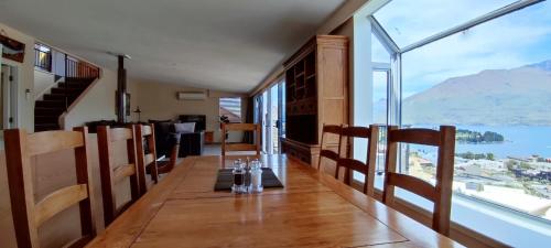a dining room with a view of the water and mountains at Spacious Home with Awesome Lake Views in Queenstown