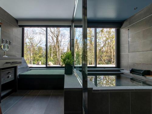 a bathroom with a large window and a bath tub at Fufu Hakone in Hakone