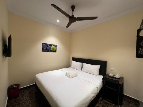 a bedroom with a large white bed with a ceiling fan at I Go Inn in Bandar Saujana Putra