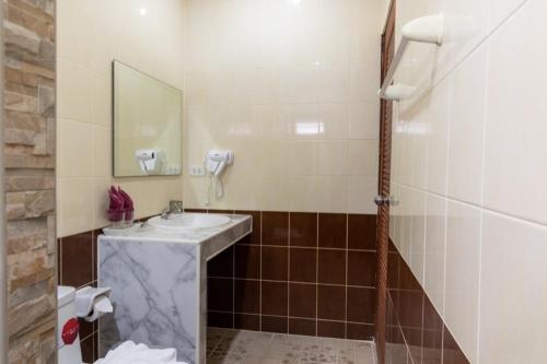 ein Bad mit einem Waschbecken und einem Spiegel in der Unterkunft The New Villa in Chaweng