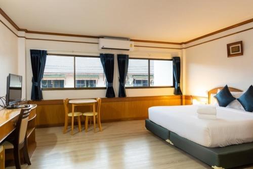 um quarto com uma cama, uma secretária e uma mesa em The New Villa em Chaweng