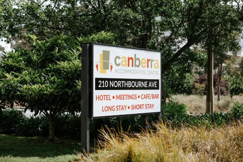 een bord voor een autodealer voor enkele bomen bij Canberra Accommodation Centre in Canberra