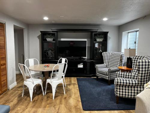 a living room with a table and chairs and a tv at Unique Home Perfect for Large Gatherings. Pets welcome! in Orem