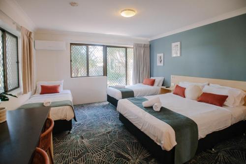 Bellara的住宿－Bribie Island Hotel，酒店客房设有两张床和一张桌子。