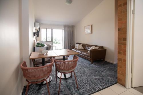 a living room with a table and chairs and a couch at Bribie Island Hotel in Bellara