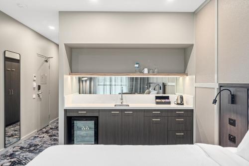 a kitchen with a sink and a bed in a room at Mercure Pakenham in Pakenham