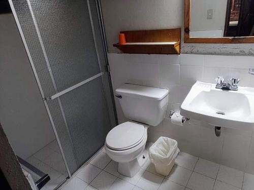 uma casa de banho com um WC, um chuveiro e um lavatório. em Hotel Real del Campo em Quetzaltenango