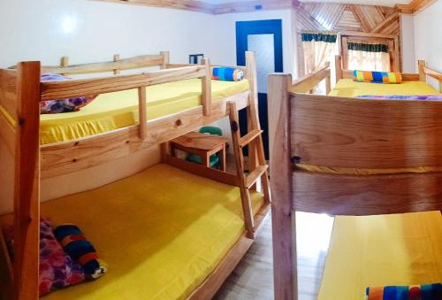 two bunk beds in a room with yellow at Sagada Younganaut Lodge in Sagada