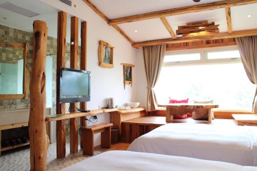 a hotel room with two beds and a tv at Shangrila Leisure Farm in Dongshan