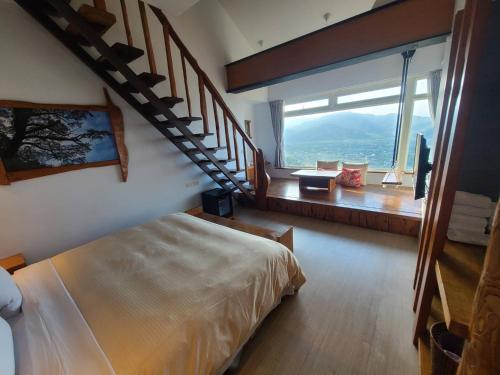 a bedroom with a large bed and a staircase at Shangrila Leisure Farm in Dongshan