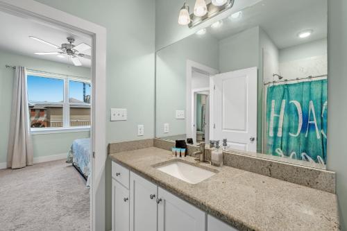 a bathroom with a sink and a large mirror at Coral Dreams in Gulf Shores