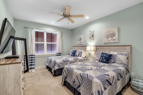 a bedroom with two beds and a ceiling fan at Coral Dreams in Gulf Shores