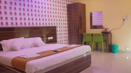 a bedroom with a large bed with a pink wall at Hills And Sea View in Port Blair