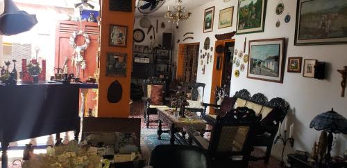 um quarto com cadeiras e quadros na parede em Mendoza’s GUEST HOUSE em Santa Ana
