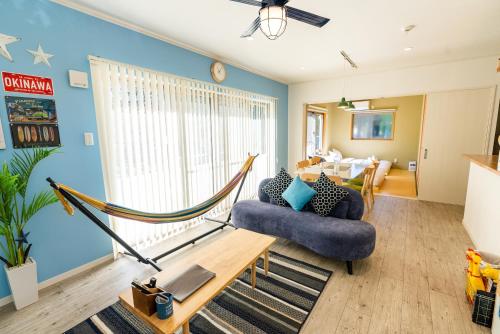 a living room with a couch and a hammock at #3LDK一軒家 #長期滞在可能 #海まで4分-- Starry Sky Resort Okinawa -- in Onna