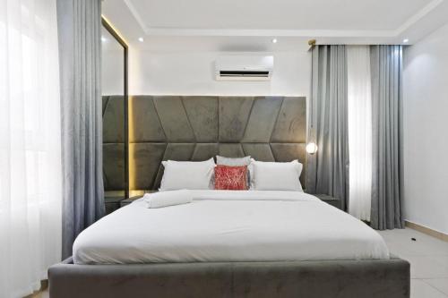 1 dormitorio con 1 cama blanca grande con almohadas rojas en Luxury 3 Bedroom Apartment In Lekki Phase1, en Lekki