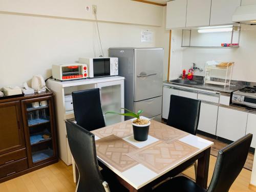 kuchnia ze stołem i krzesłami oraz kuchnia z lodówką w obiekcie K&M Heights - Vacation STAY 32223v w Tokio
