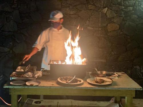 a man standing in front of a grill with fire at Royal Nest in Polonnaruwa