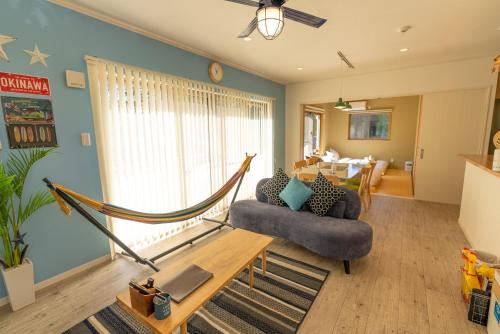 a living room with a couch and a hammock at #3LDK一軒家 #長期滞在可能 #海まで4分-- Starry Sky Resort Okinawa -- in Onna