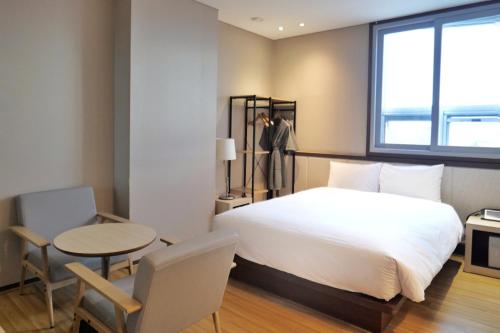 1 dormitorio con cama, mesa y ventana en Rosana Hotel, en Seúl