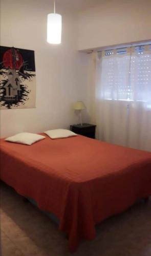 1 dormitorio con 1 cama grande con manta roja en Depto 3 ambientes zona centro en Mar del Plata
