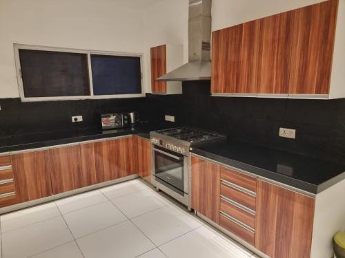 a kitchen with wooden cabinets and a stove top oven at Luxury 3 Bedroom with Pool and Gym In Oniru Victoria Island Lagos in Lagos