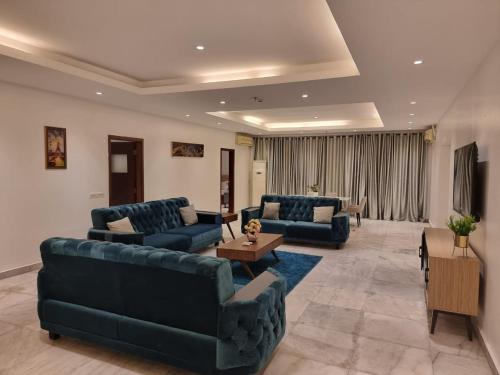 a living room with two blue couches and a table at Luxury 3 Bedroom with Pool and Gym In Oniru Victoria Island Lagos in Lagos