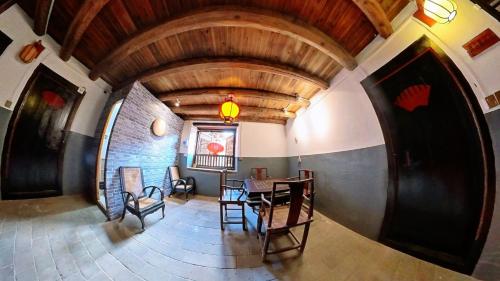 einen Blick über ein Esszimmer mit einem Tisch und Stühlen in der Unterkunft Tulou Fuyulou Changdi Inn in Yongding