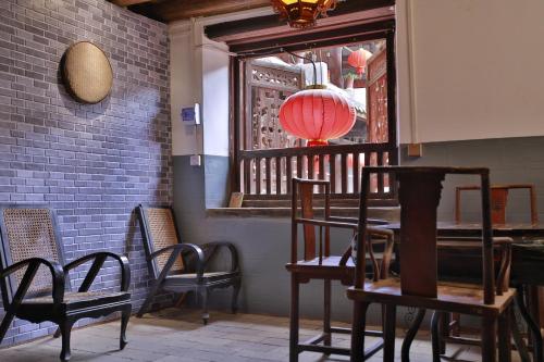 Zimmer mit Stühlen, einem Tisch und einem Fenster in der Unterkunft Tulou Fuyulou Changdi Inn in Yongding
