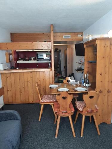 une pièce avec une table et des chaises et une cuisine dans l'établissement Studio pied des pistes Arcs 2000 - Résidence le Varet, à Bourg-Saint-Maurice