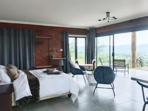 a bedroom with a bed and a table and chairs at Rocky Road Mountain Lodge in Pretoria