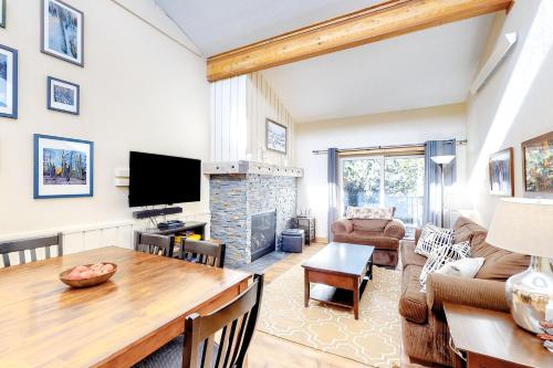 a living room with a table and a fireplace at Coziest Condo in Winter Park