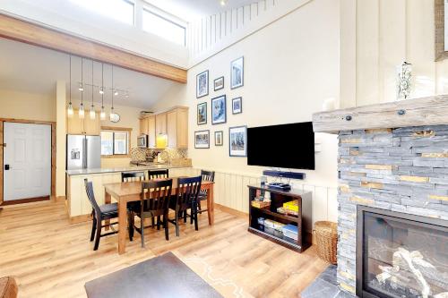 a kitchen and dining room with a table and a fireplace at Coziest Condo in Winter Park