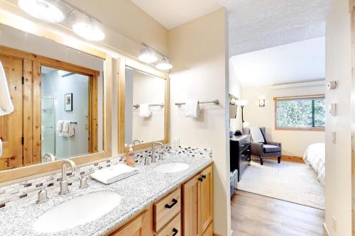 Un baño con dos lavabos y un espejo grande. en Coziest Condo, en Winter Park