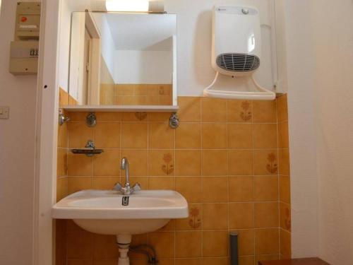 La salle de bains est pourvue d'un lavabo, d'un miroir et d'un ventilateur. dans l'établissement Studio cosy à 1200m de la plage, à proximité commerces, port et golf, parking privé inclus - FR-1-249-13, au Cap d'Agde