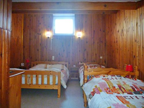 Ce lit se trouve dans un dortoir doté de murs en bois et d'une fenêtre. dans l'établissement Appartement près de la plage avec balcon et parking, idéal pour 6 personnes - FR-1-387-154, à Marseillan