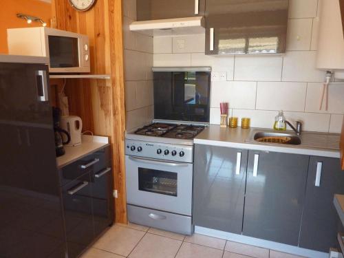 une cuisine avec une cuisinière et un évier dans l'établissement Appartement près de la plage avec balcon et parking, idéal pour 6 personnes - FR-1-387-154, à Marseillan
