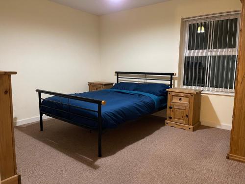 a bedroom with a bed with blue sheets and a window at Two bedroom Entire Apartment in Roman road with Free Parking in Middlesbrough