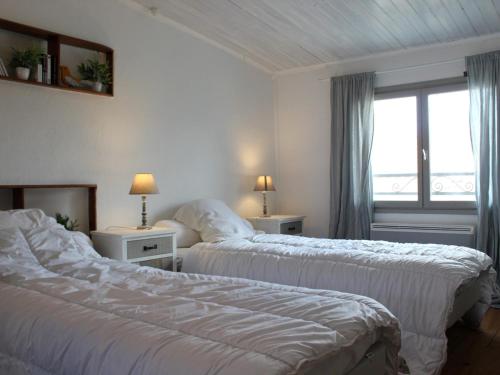 2 Betten in einem Hotelzimmer mit Fenster in der Unterkunft Maison Saint-Georges-d'Oléron, 3 pièces, 4 personnes - FR-1-246A-85 in Saint-Georges-dʼOléron