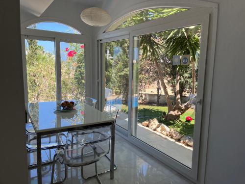 a dining room with a table and two sliding glass doors at Villa Neyla Four bedroom Coral Bay Beach front in Coral Bay