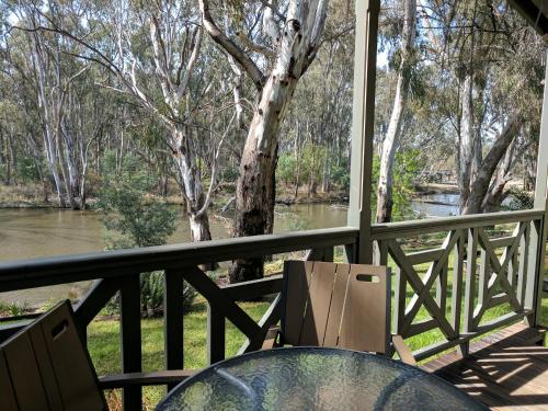 a table and chairs on a balcony overlooking a river at Moama Riverside Holiday Park in Moama