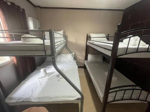 a room with two bunk beds in a room at Townes Huge Home Big Grps Big Fam Near SM Ecoland DGT Coastal road ADDU UM in Davao City