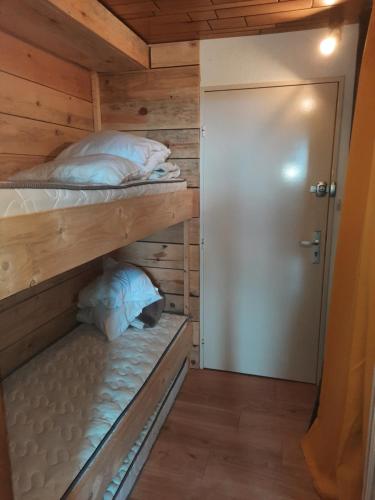 a bedroom with two bunk beds in a wooden cabin at Le lorrane in Muhlbach-sur-Munster