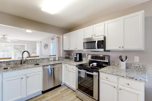 a kitchen with white cabinets and stainless steel appliances at Bethany Bay --- 37514 Pettinaro Dr # 9404 in Ocean View