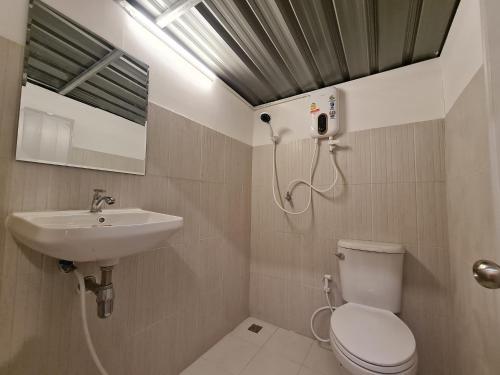 a bathroom with a sink and a toilet and a mirror at SB Inn in Phetchaburi