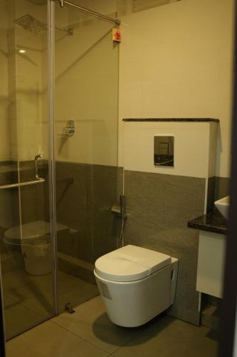 a bathroom with a toilet and a glass shower at RJ ROSS RAMAPURAM in Munnar