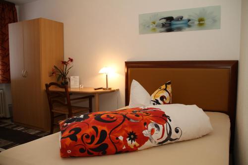 a bedroom with a bed and a table with a chair at Gasthaus zur Grässelmühle in Sasbach in der Ortenau